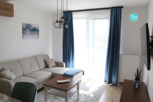 a living room with a couch and a table at St.Gotthard Apartman in Szentgotthárd