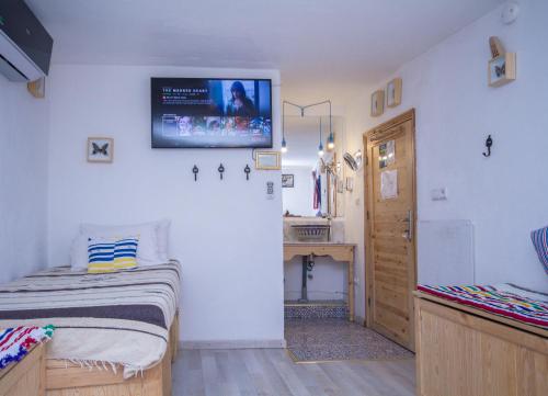 a bedroom with a bed and a tv on the wall at USHA Guest House in Chefchaouene