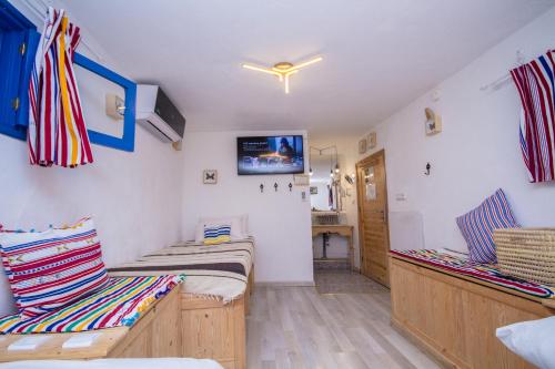 a room with two beds and a tv on the wall at USHA Guest House in Chefchaouene