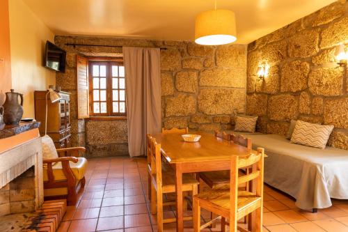 a room with a table and a bed and a table and chairs at Quinta Do Crestelo Aparthotel in Seia