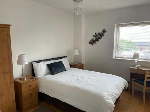 a bedroom with a bed and a desk and a window at Wexford Town Centre Apartment in Wexford
