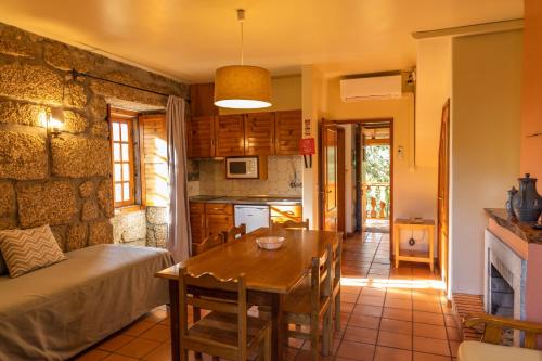 a kitchen and dining room with a table and a couch at Quinta Do Crestelo Aparthotel in Seia