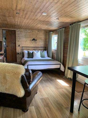 1 bedroom woodland cabin في لاونسستون: غرفة نوم بسرير واريكة في غرفة