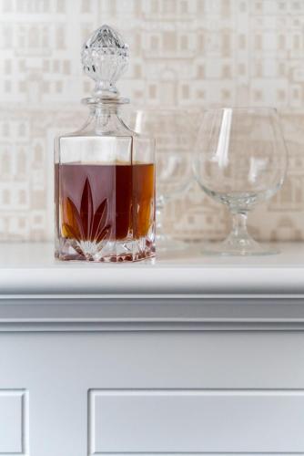 a bottle of whiskey and two glasses on a table at Albergo Rossini 1936 - Small & Charming in Bologna