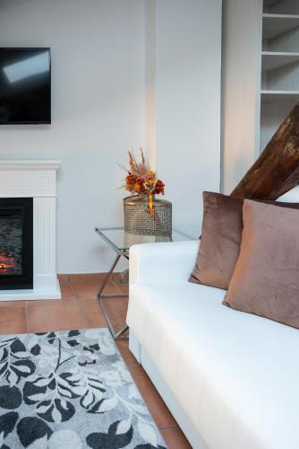 a living room with a white couch and a fireplace at Albergo Rossini 1936 - Small & Charming in Bologna