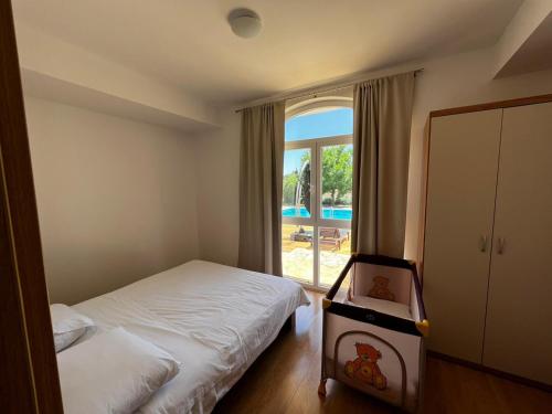 1 dormitorio con cama y ventana grande en Orange Tree Garden en Kastel Stafilic