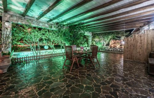 a dining room with a table and chairs and plants at Emilia's Little Farmhouses in Agii Anargiri Milos