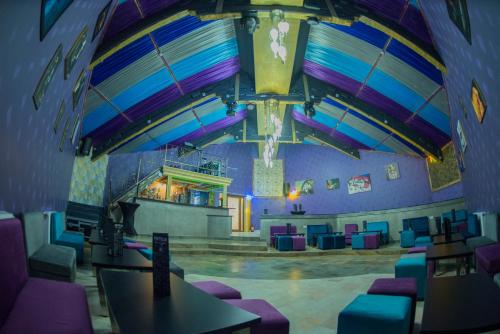 a room with purple and blue chairs and a stage at Voila Inn Predeal in Predeal