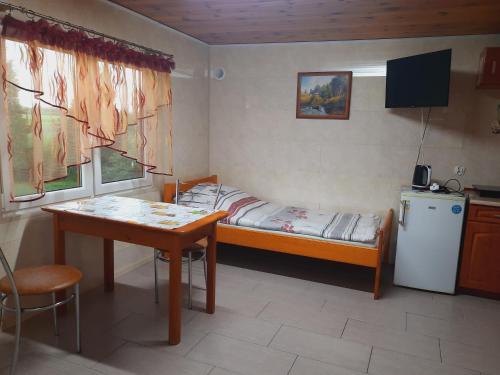 a small room with a small bed and a table at Agroturystyka nad Biebrza Sośniaki in Goniadz