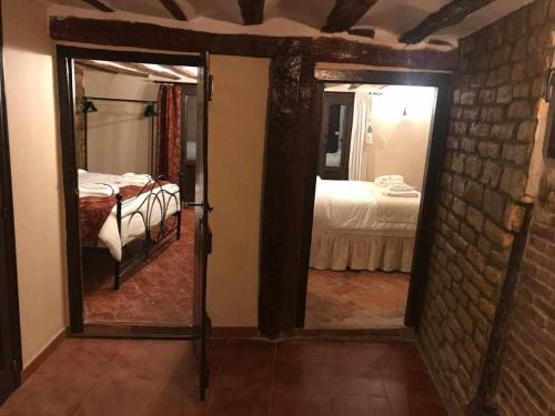 Habitación con dormitorio con cama y espejo. en La Posada de Leza Your wine country getaway, en Laguardia