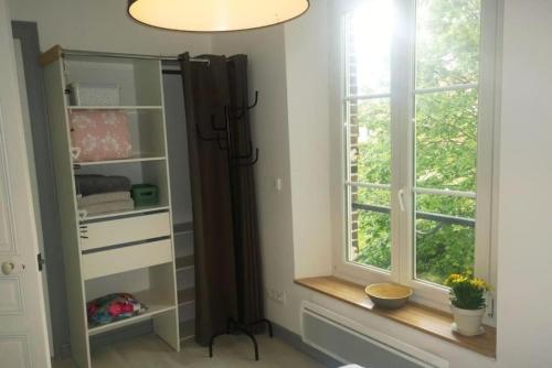 a dressing room with a window and a mirror at Entre ville et jardins in Sainte-Savine