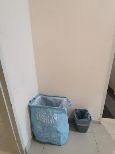 a blue bag on the floor next to a trash can at Rustic one bedroom unit for 4pax by Jomy Management in Lumut