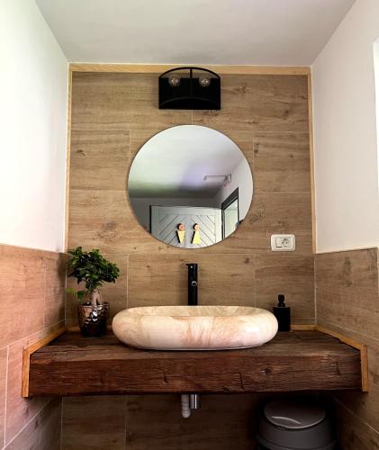 a bathroom with a large mirror and a sink at Flore's Garden Glamping in Bran