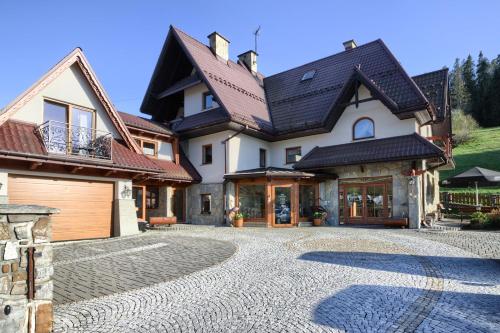 uma casa grande com uma entrada em frente em Willa Bartuś Baliczek em Bukowina Tatrzańska