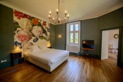 a bedroom with a bed and a painting on the wall at Château Origny de Neuvy in Neuvy