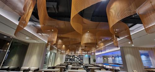 a dining room with tables and chairs and a ceiling at Fifth Pattaya Jomtien By Shiwalai Int in Jomtien Beach