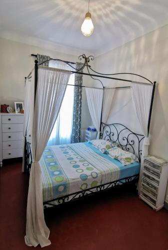 une chambre avec un lit à baldaquin dans l'établissement Our home, Cozy Apartment two minutes from the sea - Clima, à Nice