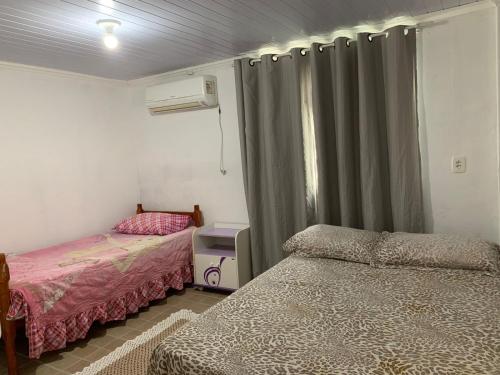 una camera con due letti e una finestra con tende di Casa da Vila a Porto Belo