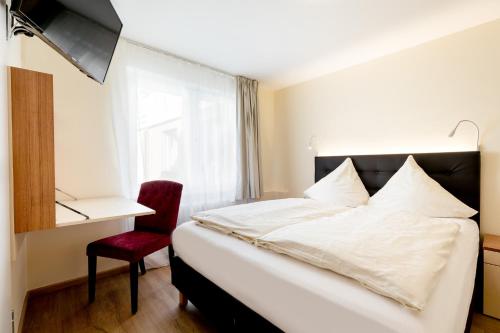 um quarto com uma cama, uma cadeira e uma janela em Hotel Helgolandia em Helgoland