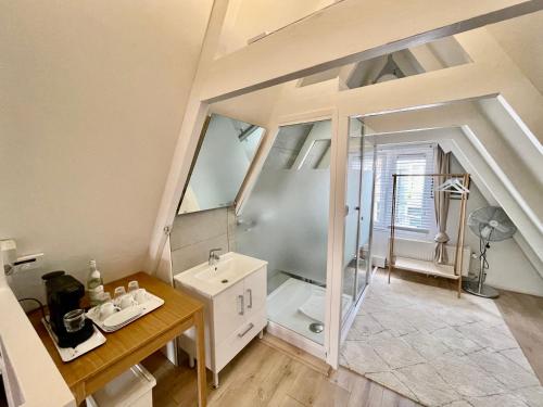 uma casa de banho no sótão com um lavatório e um chuveiro em Olive Bed and Breakfast em Amsterdã