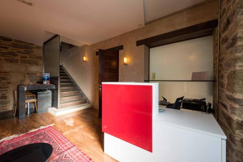 a room with a red counter and a staircase at Posada Real de Las Misas in Puebla de Sanabria