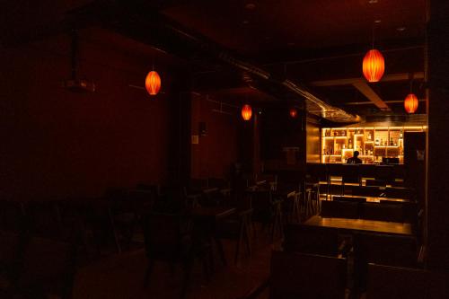a dark room with tables and chairs and lights at Moskva Hotel in Madurai