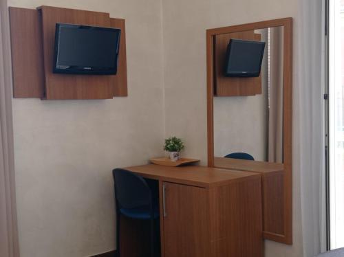 a room with a desk with a tv and a mirror at Rome Travellers Hotel in Rome