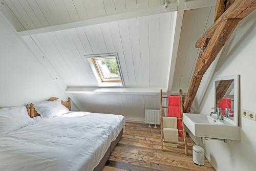 a bedroom with a bed and a sink in a attic at TopLocatiezeeland # Walcheren in Meliskerke