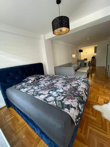 a bedroom with a bed and a living room at Apartman CITY CENTER 4-šetalište in Prijedor