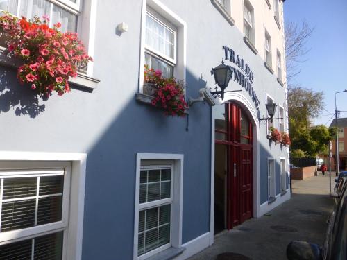 トラリーにあるTralee Townhouseの赤い扉と花の青白の建物