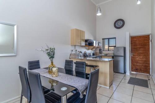 a kitchen and dining room with a table and chairs at Cozy All-in-One Ocean View Apartment in Kingsburgh