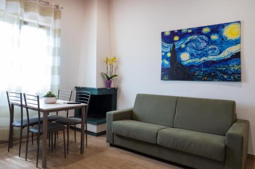 a living room with a couch and a table and a painting at Stella Marina - Camere e Monolocali Turistici in Monte San Biagio