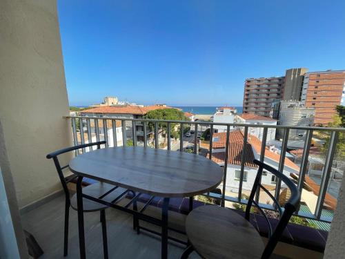 una mesa y sillas en un balcón con vistas al océano en Acogedor estudio en la playa, con vistas al mar, y piscina comunitaria, en Sant Salvador