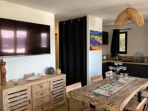 une salle à manger avec une table et une télévision murale dans l'établissement Chez Marie-Pierre, aux Angles