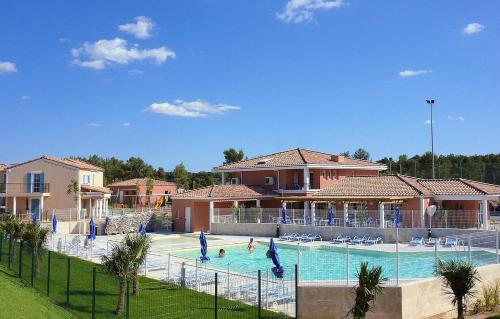 a swimming pool with people playing in it at Les Maisons du Golf de la Cabre d'Or by Ateya Vacances in Cabriès