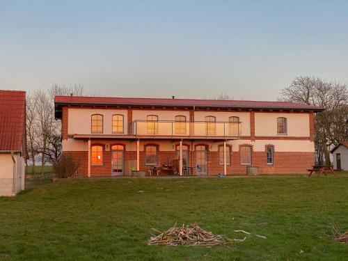 a large brick house with a grass field in front of it at Ferienwohnungen Ostseestern in Rakow