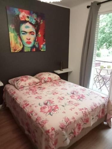 a bedroom with a bed with a painting on the wall at Joli F2 neuf tout équipé proche centre Annecy et Gare in Annecy