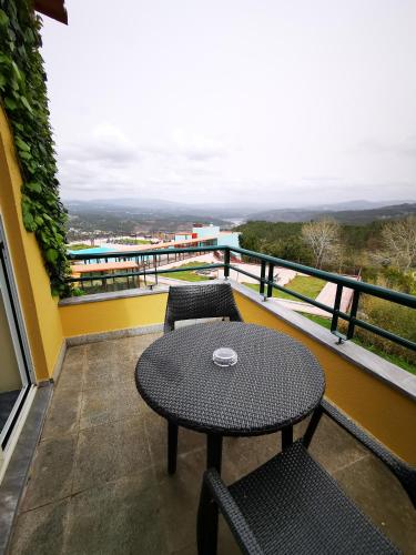 a table and chairs on a balcony with a view at Hotel Da Montanha in Pedrógão Pequeno