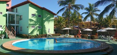 a swimming pool in front of a building with a resort at JL Temporadas - Apto Village Taperapuan in Porto Seguro