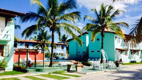 a resort with palm trees and a swimming pool at JL Temporadas - Apto Village Taperapuan in Porto Seguro