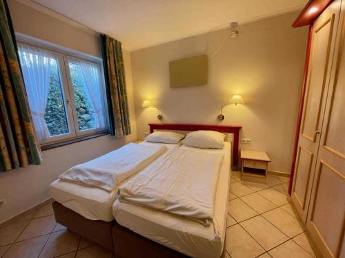 een slaapkamer met een groot bed en een raam bij Haus Niedersachsen Apartment 12 in Timmendorfer Strand