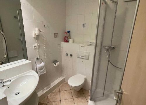 een badkamer met een douche, een toilet en een wastafel bij Haus Niedersachsen Apartment 12 in Timmendorfer Strand