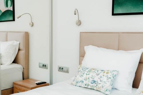 a bedroom with a white bed with a pillow at Natura Luxury Suites Parga in Parga