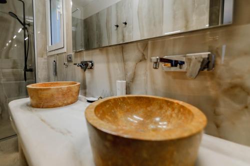 a bathroom with two wooden sinks on a counter at Natura Luxury Suites Parga in Parga