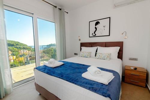 a bedroom with a bed and a large window at Natura Luxury Suites Parga in Parga