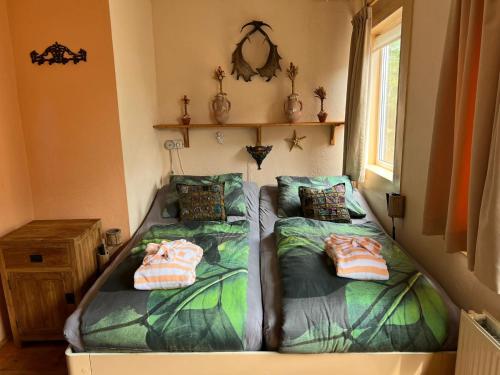 2 bedden in een kamer met 2 bedden, waarvan 1 tweepersoonsbed en 1 eenpersoonsbed. bij La Cabaña in Zandvoort