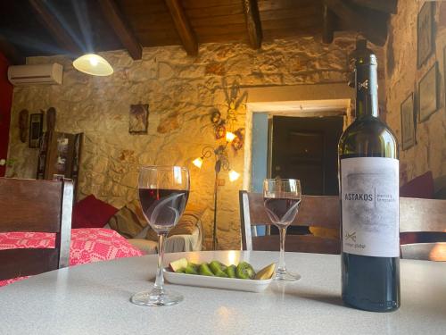 a bottle of wine sitting on a table with two glasses at Platanus Apartment in Vanáton