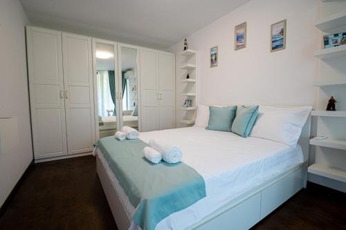 Un dormitorio blanco con una cama con toallas. en Stylish 1-BD Apartment in St. Constantine and Helena en Saints Constantine and Helena