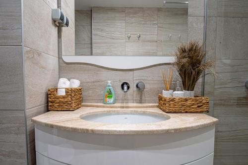 un baño con lavabo con cestas. en Stylish 1-BD Apartment in St. Constantine and Helena en Saints Constantine and Helena
