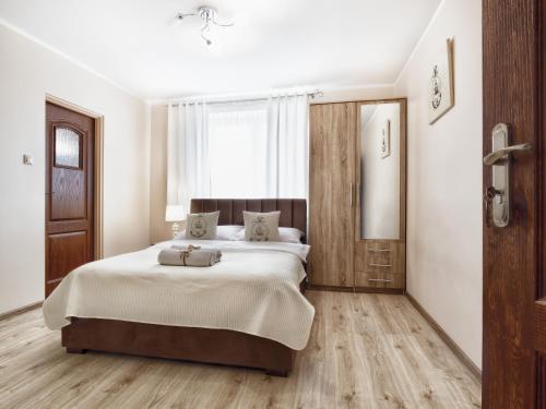 a bedroom with a large bed and a window at Willa Kapitańska i Willa Marynarska in Łeba
